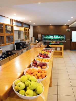 Un bufé con diversas frutas y una estación de café.