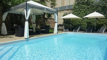 Een seizoensgebonden buitenzwembad, parasols voor strand/zwembad