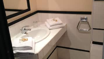 Un baño con lavamanos, espejo e inodoro.