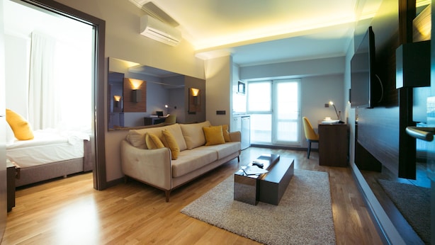 A modern living room with a sofa, coffee table, and a TV mounted on the wall. - Anka City (Ankara)