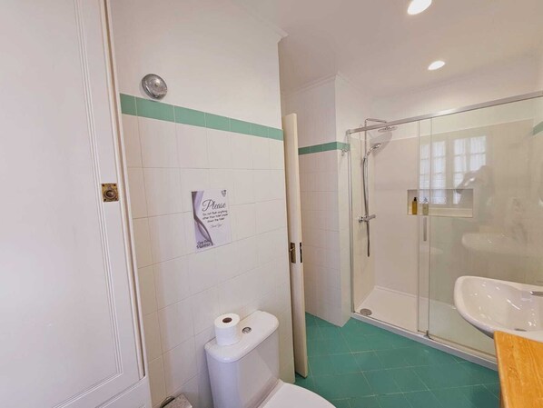 A bathroom with a toilet, a shower, and a sink. - Casa das Videiras (Porto Moniz)