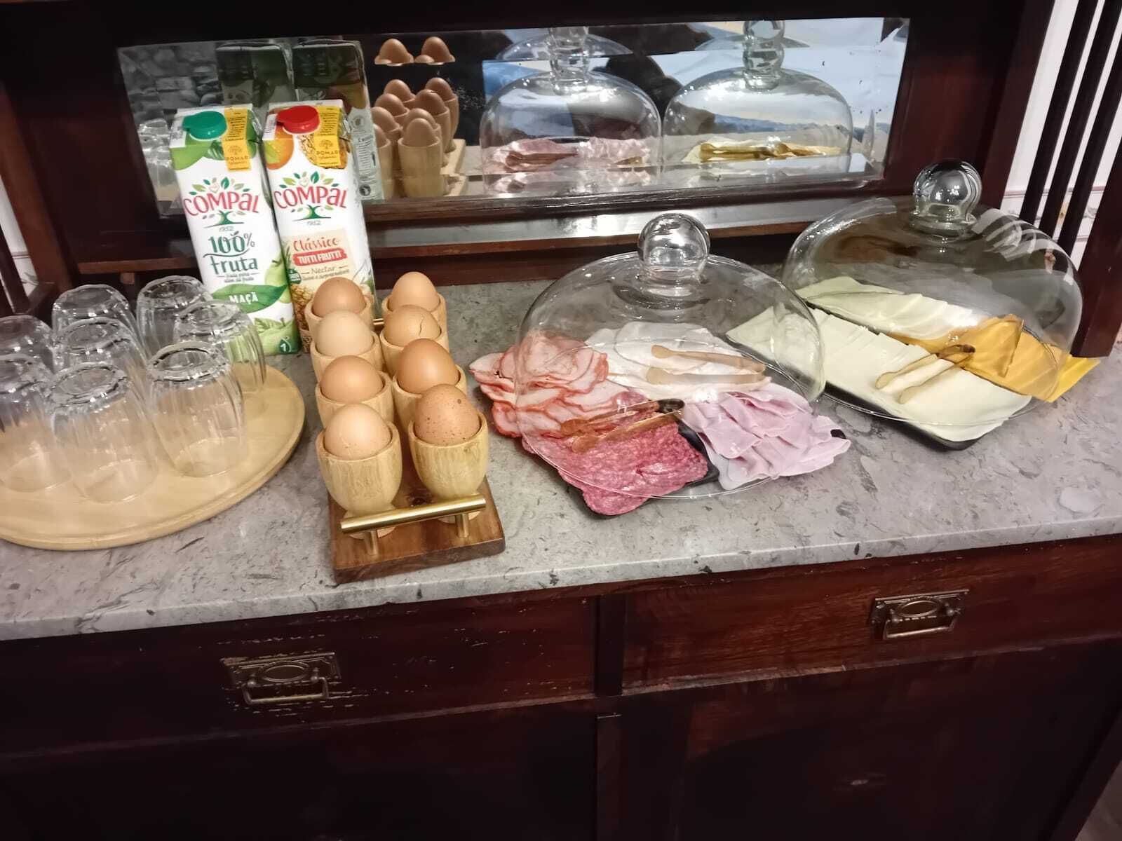 A breakfast buffet with various food items including eggs, meats, and dairy products.