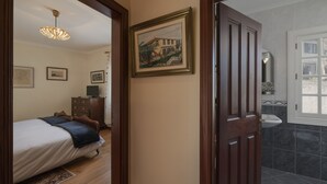 A bedroom with a bed, a dresser, and a framed picture on the wall. - Casa das Videiras (Porto Moniz)