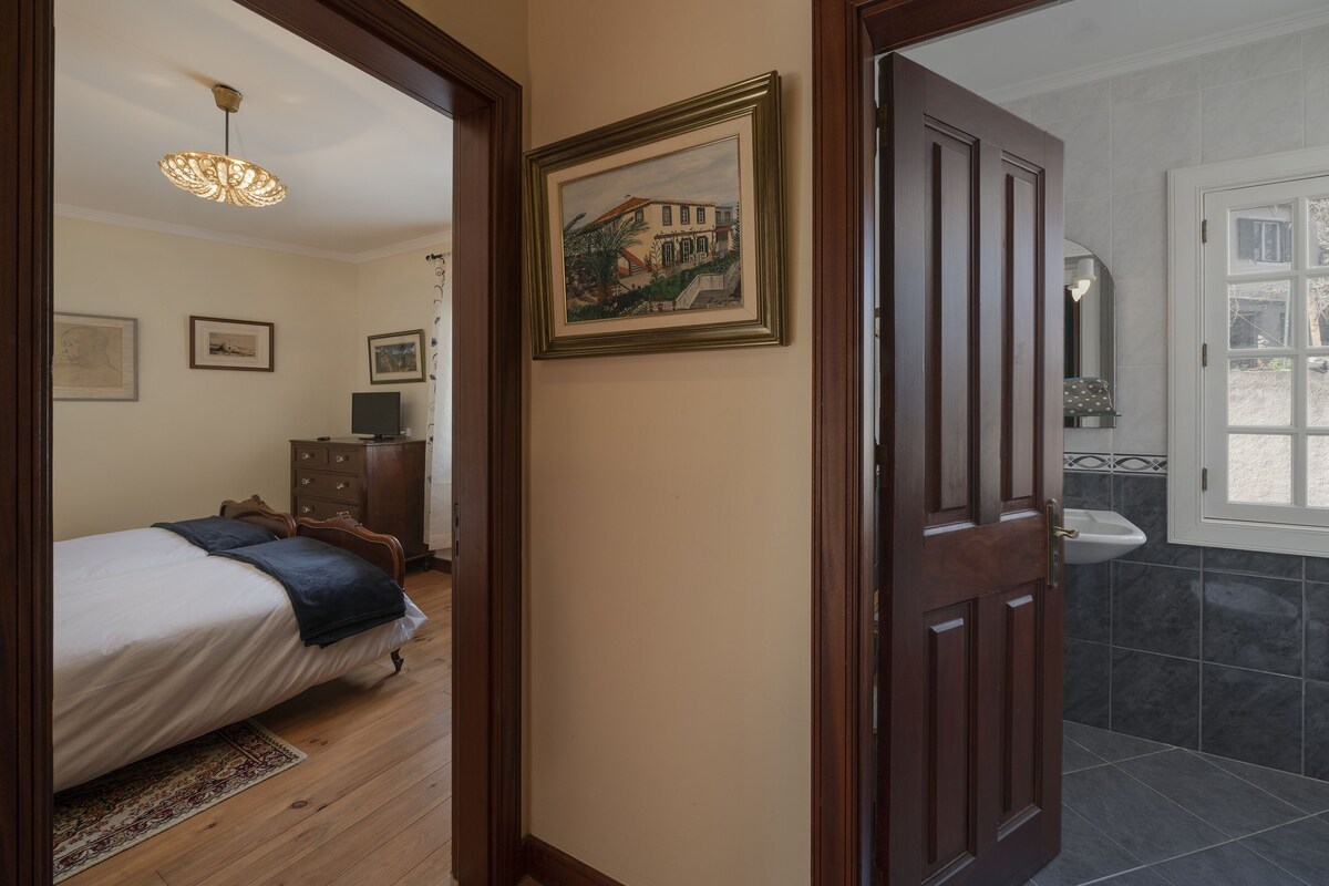Une chambre à coucher avec un lit, une commode et un tableau encadré accroché au mur.