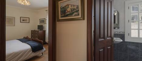 A bedroom with a bed, a dresser, and a framed picture on the wall.
