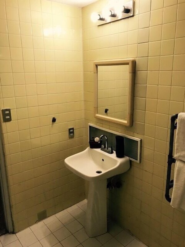 A bathroom with a sink, mirror, and towel rack. - Pachamama - Hotel - Hostel (Managua)