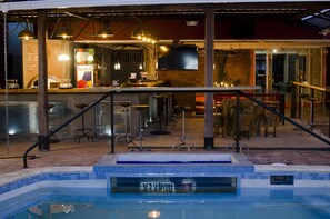 A bar area with a pool, bar stools, and a Red Bull advertisement.