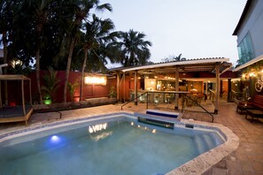 Un espace piscine comprenant un jacuzzi, un patio couvert et un coin bar.