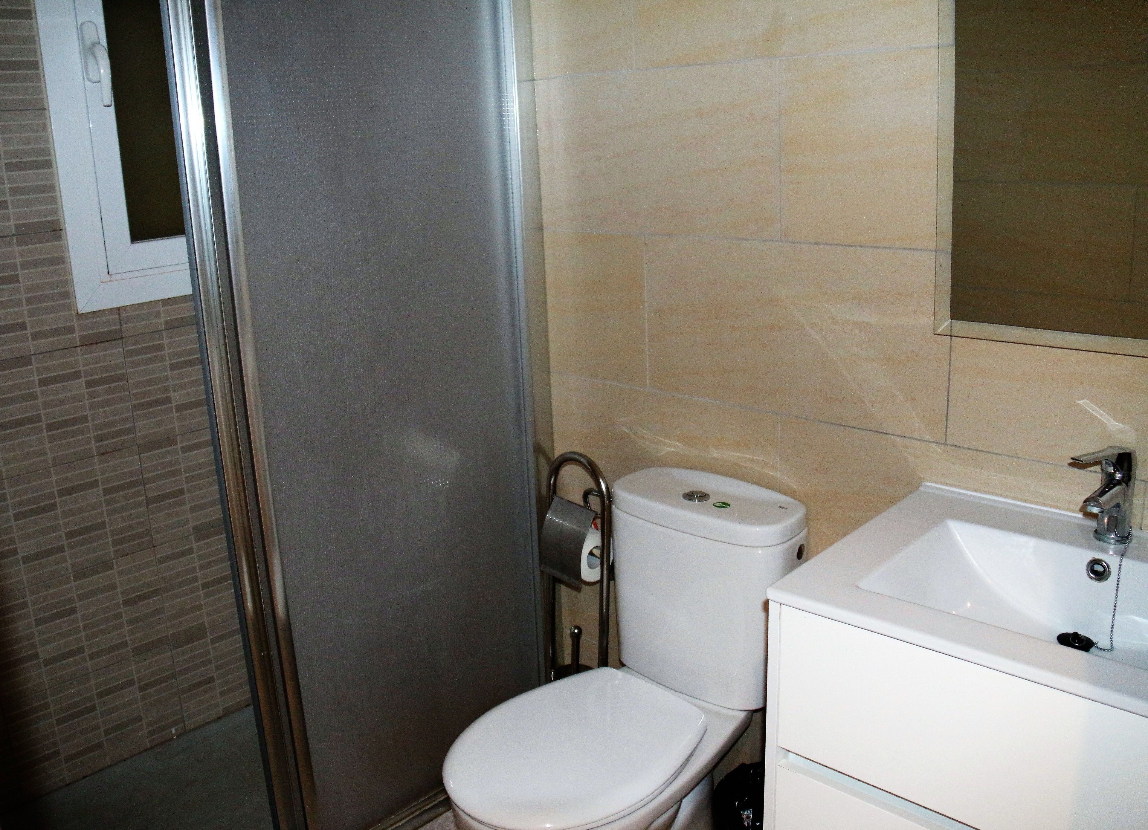 A bathroom with a toilet, sink, and shower.