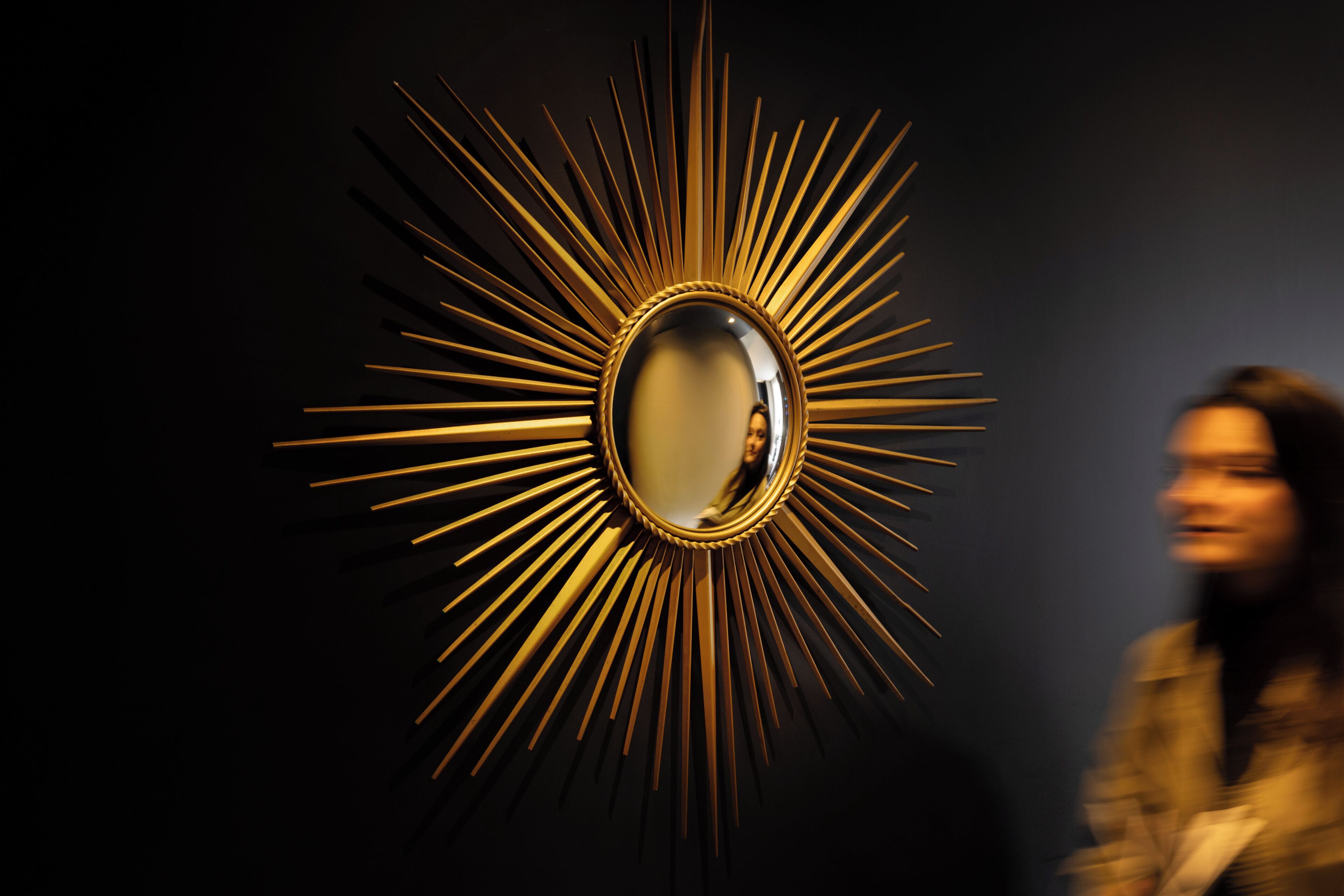 Espejo con diseño de sol y superficie reflectante.