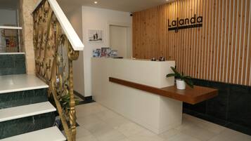 Una mesa de recepción con un panel de pared de madera y un letrero que dice 'La Janda Hostel'.