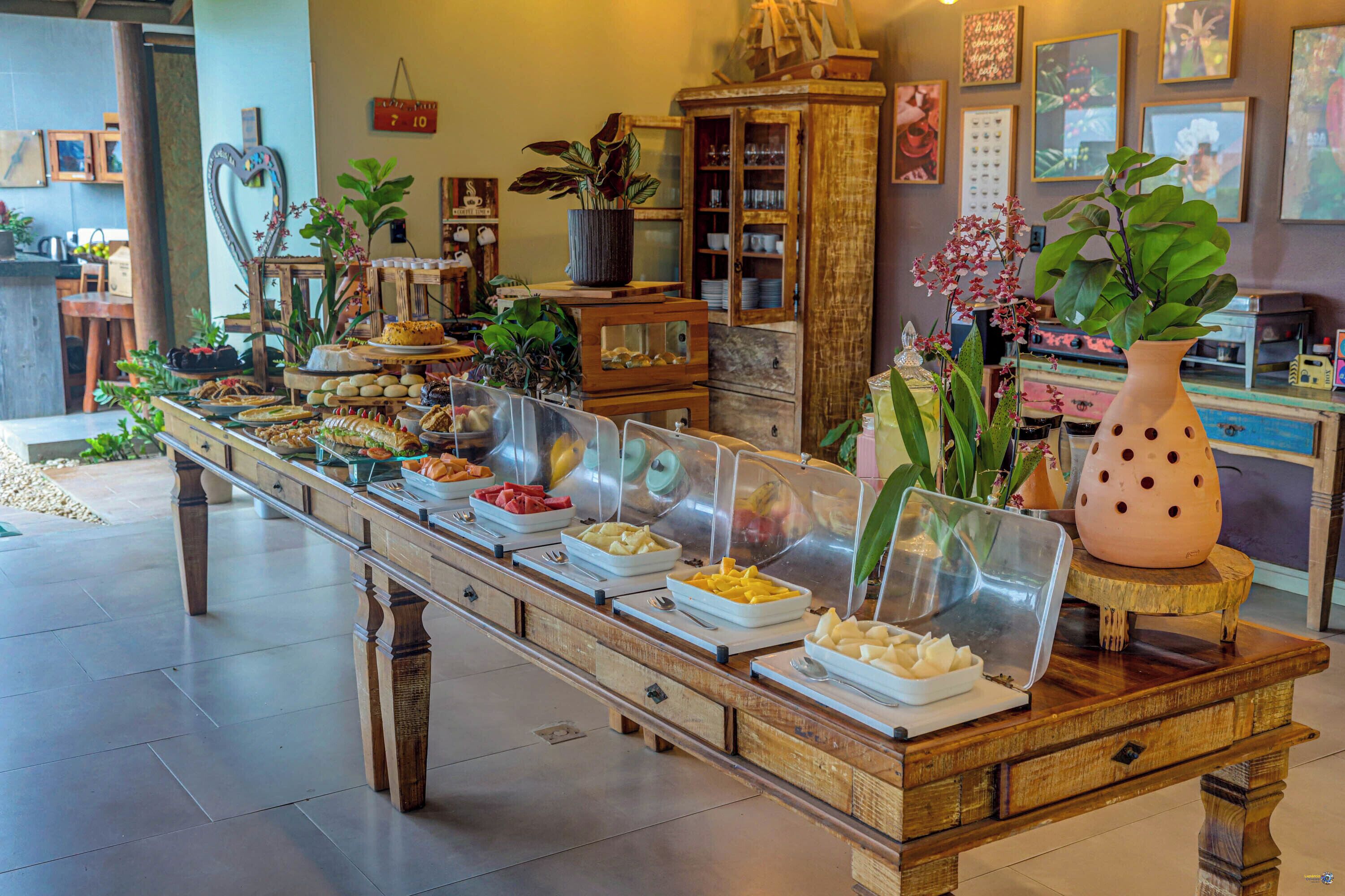 A buffet with various food items, a wooden cabinet, and decorative plants.