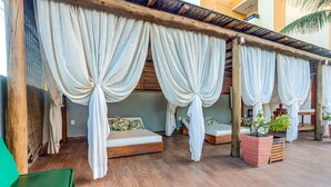A room with two beds, white curtains, wooden flooring, and a potted plant. - Pousada Praia Bela (Ilhéus)