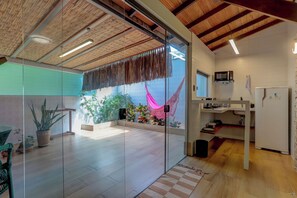 A modern kitchen with a microwave, refrigerator, and wooden beams on the ceiling. - Pousada Praia Bela (Ilhéus)
