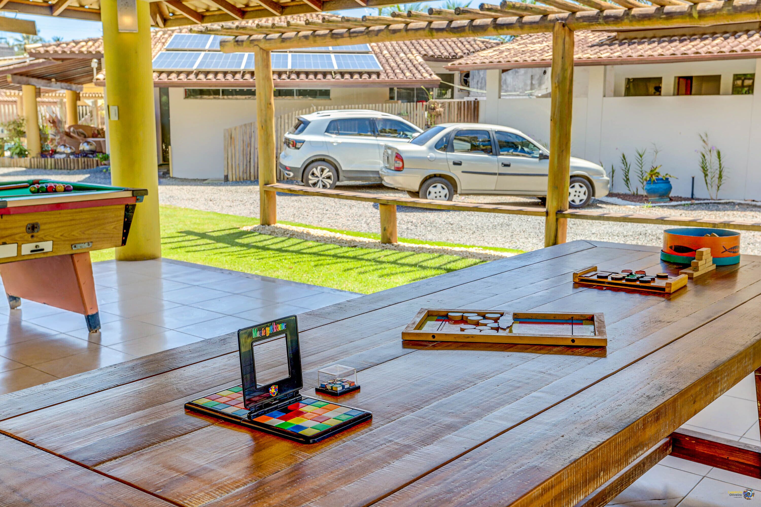 A wooden table with a pool table, a dartboard, and a Rubik's cube.