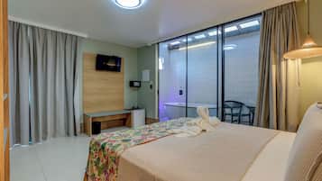 A hotel room with a bed, a TV, a desk, and a chair.