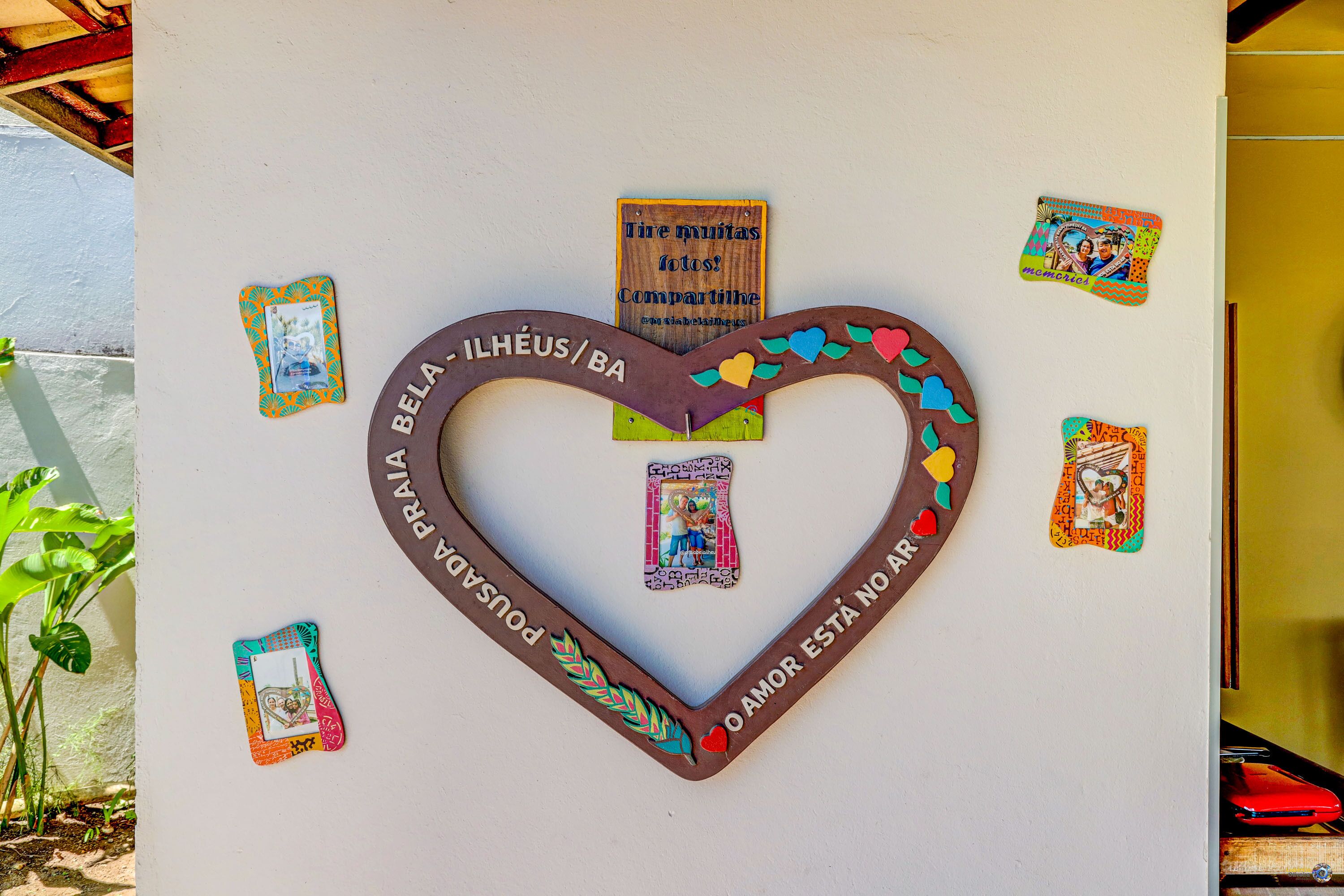 Decoración en forma de corazón con texto y tarjetas pequeñas en una pared.