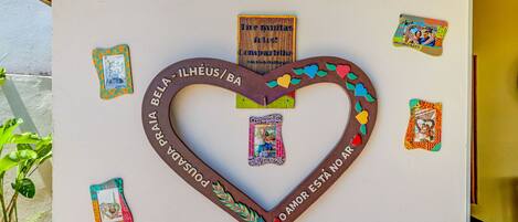 Decoración en forma de corazón con texto y tarjetas pequeñas en una pared.