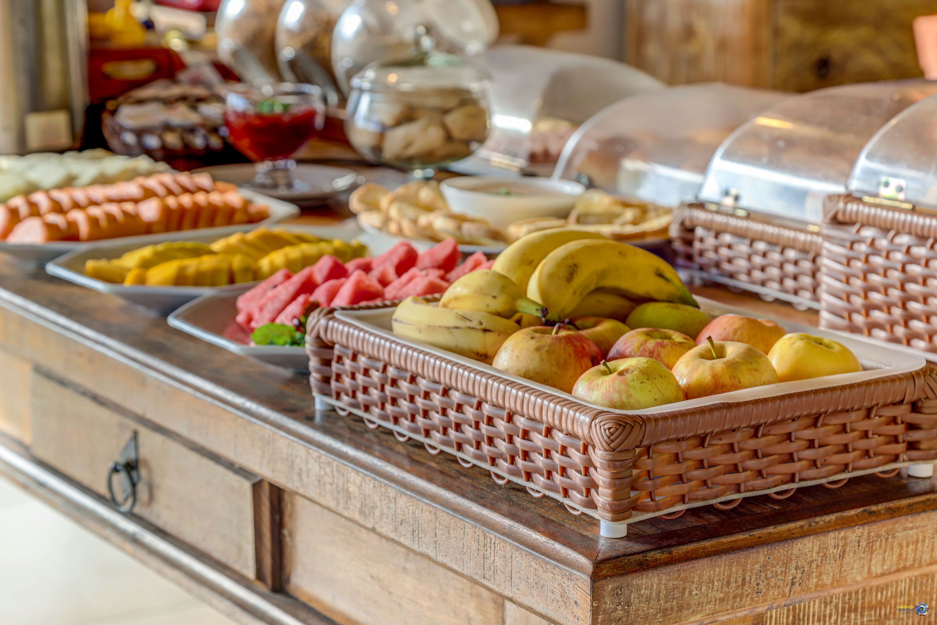 Un bufé con diversas frutas y pasteles.