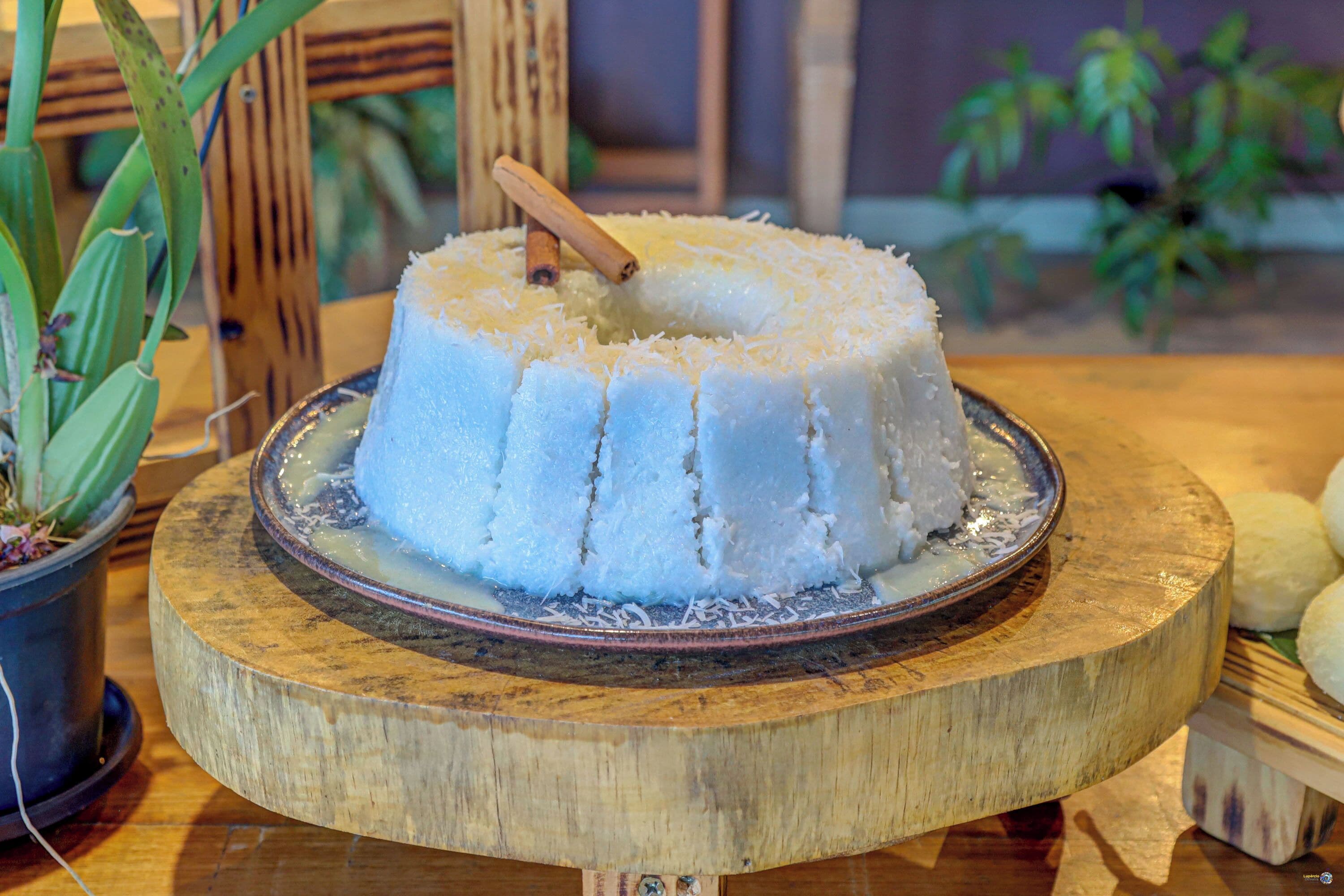 A cake on a wooden board with a wooden stick on top.