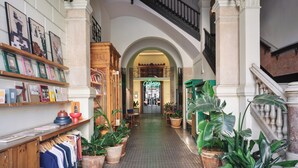 Un pasillo con una escalera, plantas en macetas y un letrero que dice "Aventura".