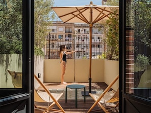 A balcony with a view of a building, a table, and two chairs. - Hotel Casa Bonay & Spa (Barcelona)