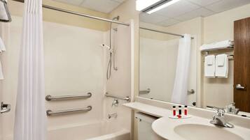 A bathroom with a bathtub, a toilet, a sink, and a mirror.