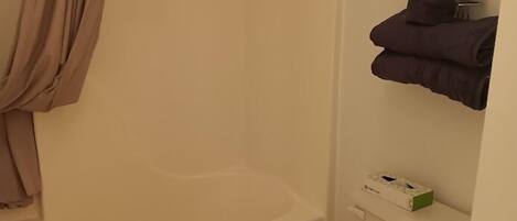 Un baño con bañera, inodoro y un perchero para toallas.