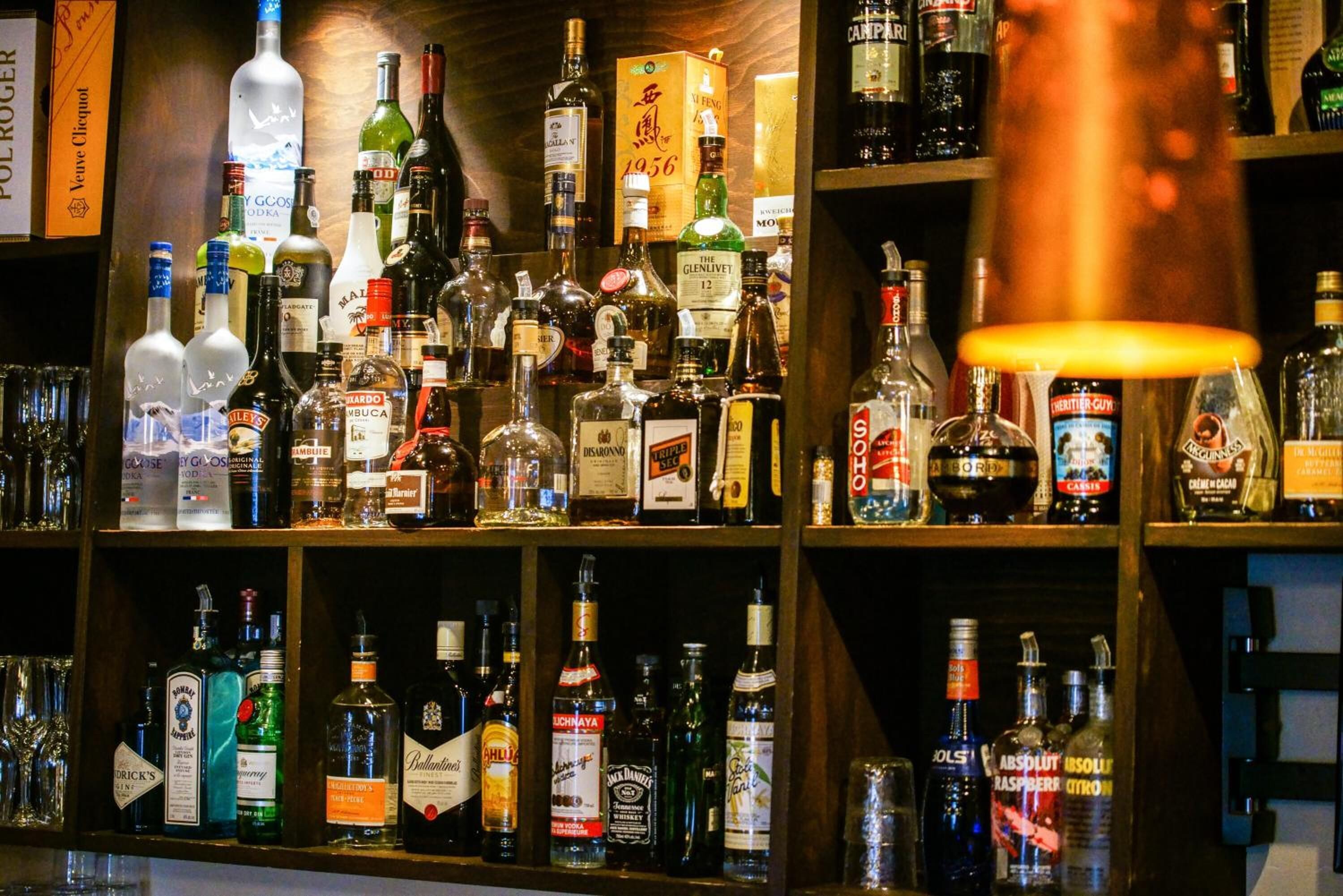 Un bar con estantes llenos de botellas de licores.