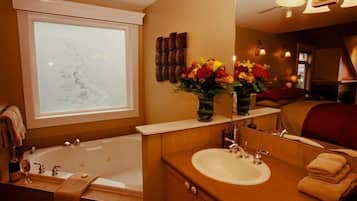 A bathroom with a bathtub, a sink, a mirror, and a window.