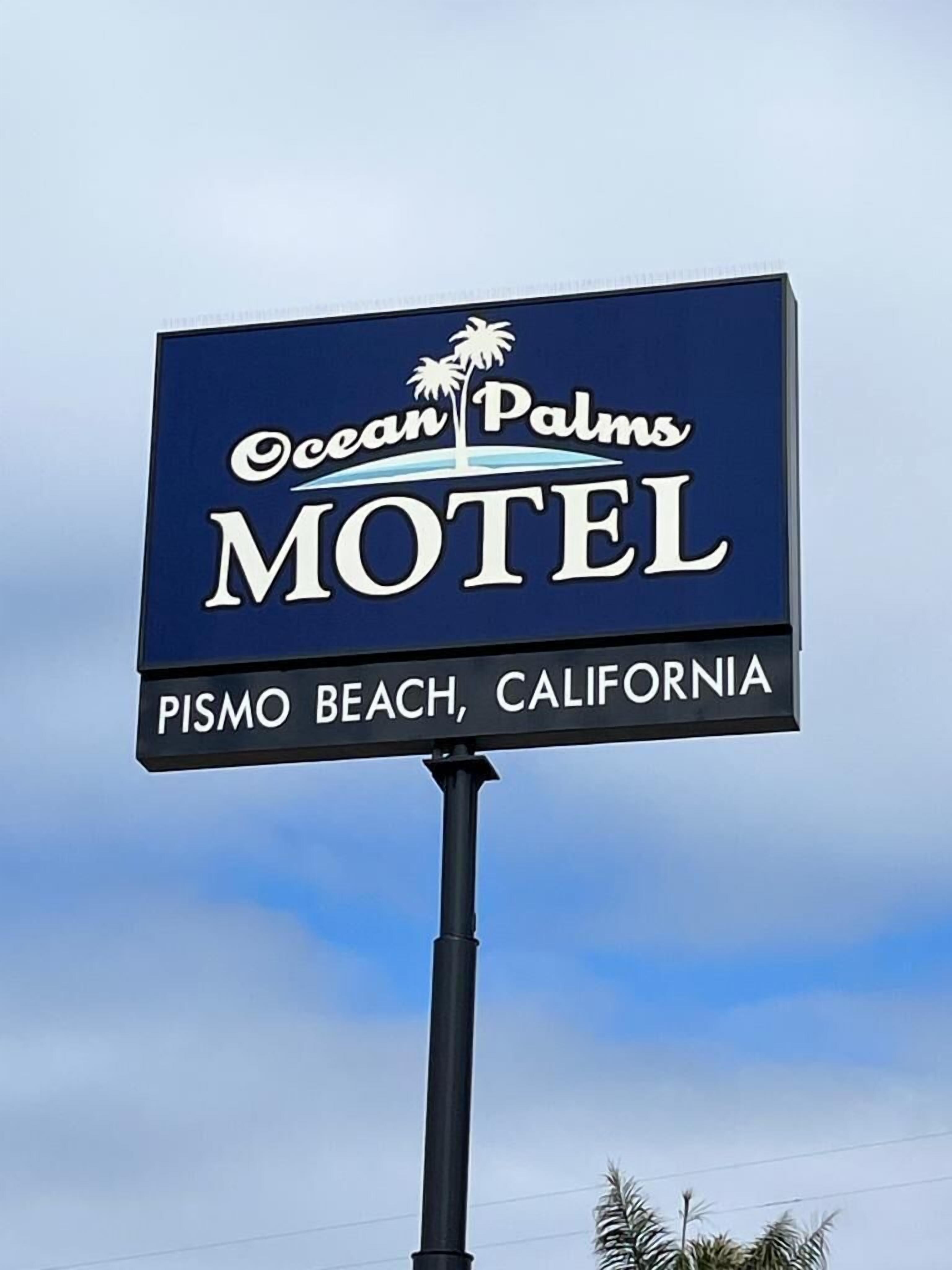 Une enseigne de motel indiquant le nom « Ocean Palms Motel » et l’emplacement « Pismo Beach, Californie ».