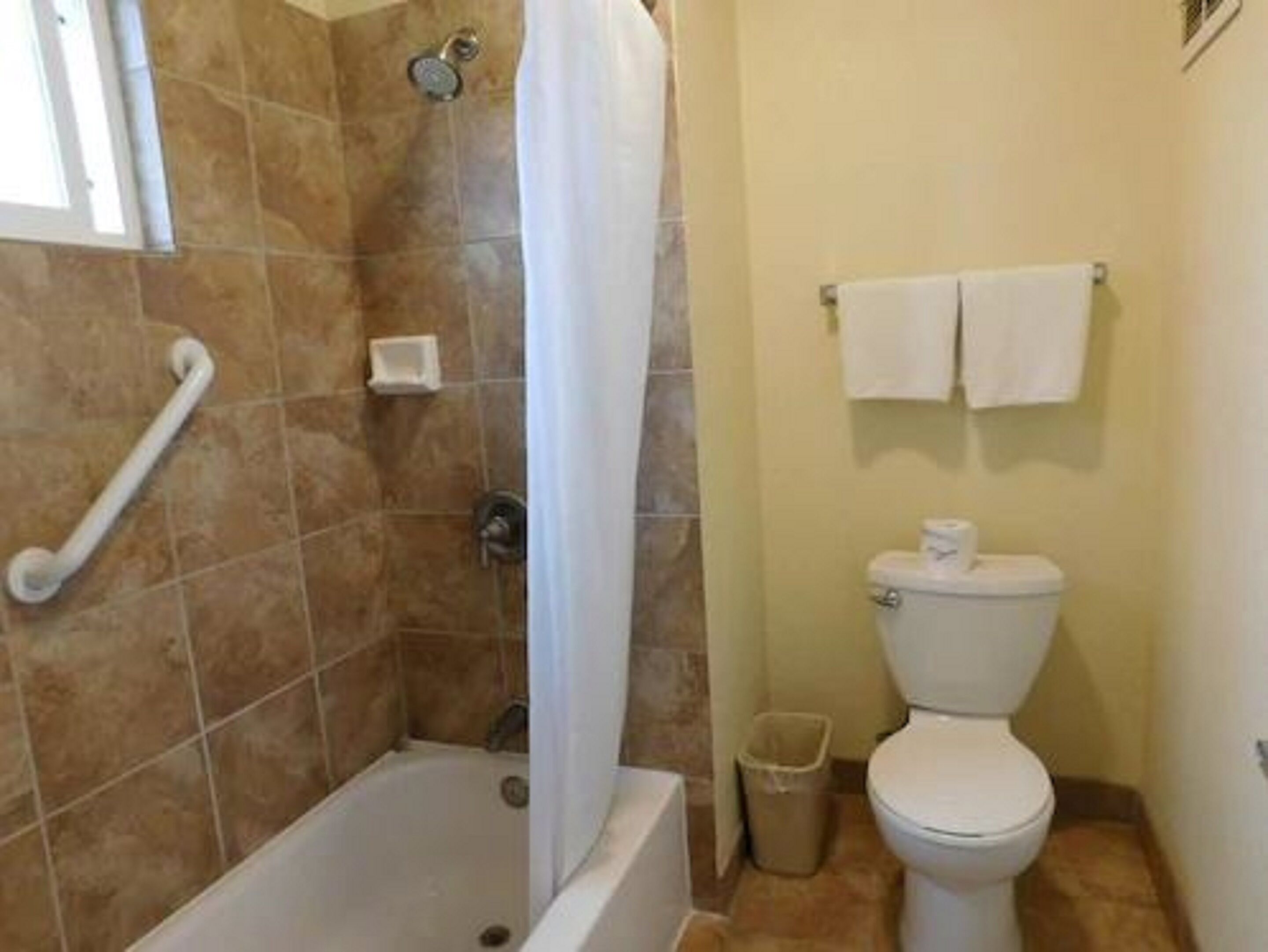 A bathroom with a bathtub, a toilet, and a shower.