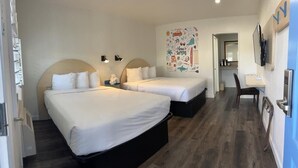 A hotel room with two beds, a desk, and a chair. - Ocean Palms Motel (Pismo Beach)