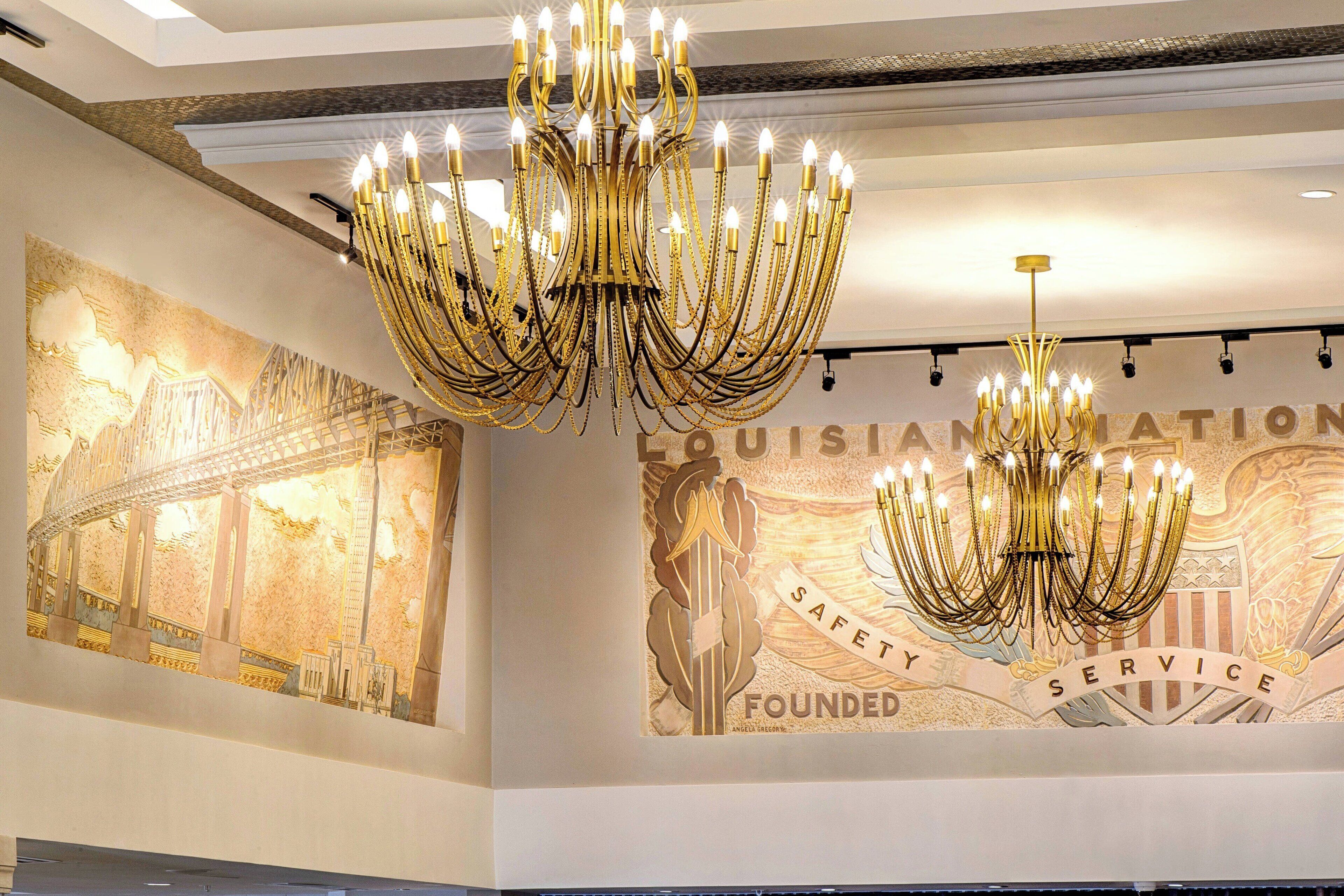 A grand chandelier and a mural of the Louisiana State Capitol with the words "SAFETY SERVICE" and "FOUNDATION".