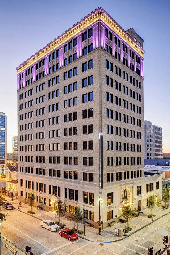 A multi-story hotel with a classic architectural design, featuring a central entrance and a parking area in front. - WATERMARK Baton Rouge, Autograph Collection (Baton Rouge)