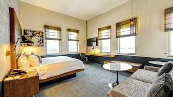 A hotel room with a bed, a desk, a sofa, and a TV.