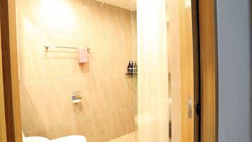 A modern bathroom with a toilet, a towel rack, and a shower area.