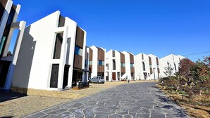 A row of modern, white buildings with dark brown accents and large windows. - JejuSorang (Jeju City)