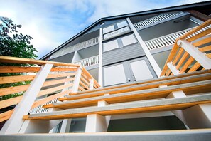 Stunning multi-level building with a spacious balcony area and steps leading up to it.