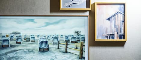 Three framed artworks on a textured wall.