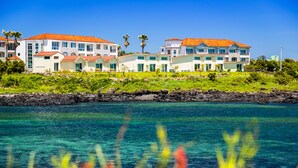 A coastal hotel with multiple buildings, a clear view of the ocean, and a rocky shoreline. - Jeju Turning Point (Seogwipo)