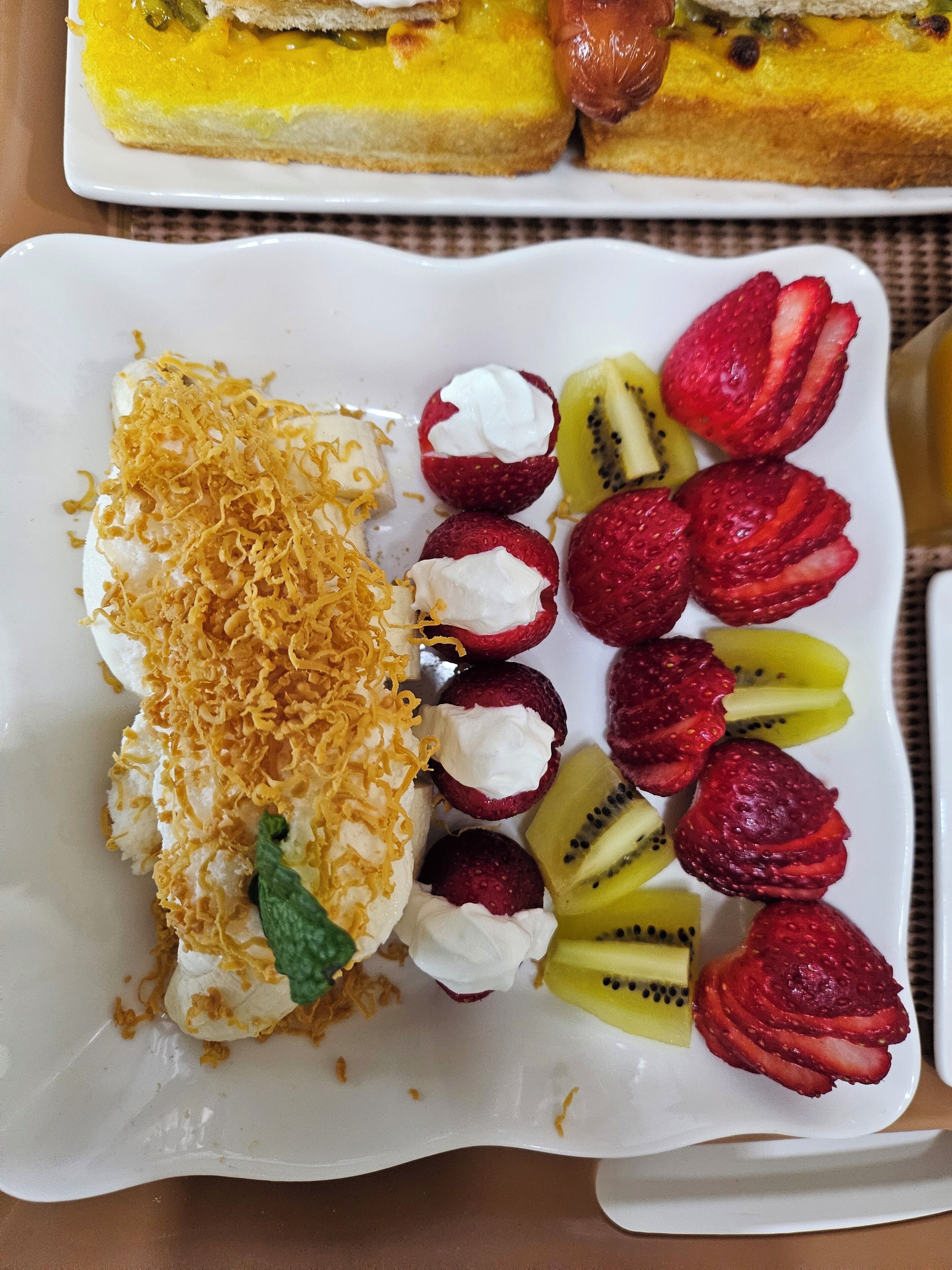 A dessert plate with various fruits and a pastry.