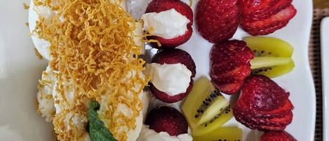 A dessert plate with various fruits and a pastry.