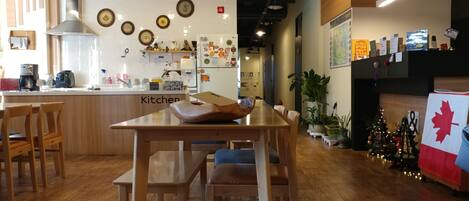 A modern kitchen with wooden furniture, a central island, and a dining area.