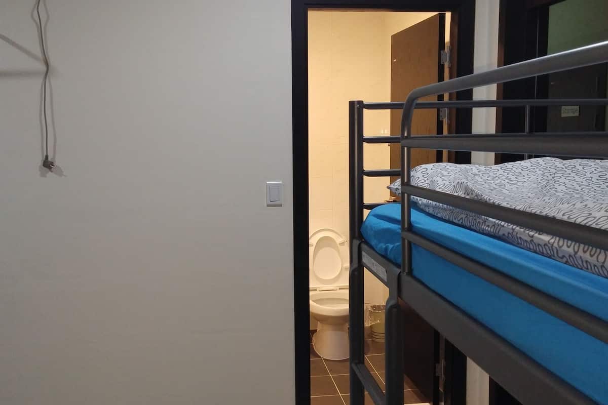 A small, compact room with a bunk bed, a toilet, and a storage area.