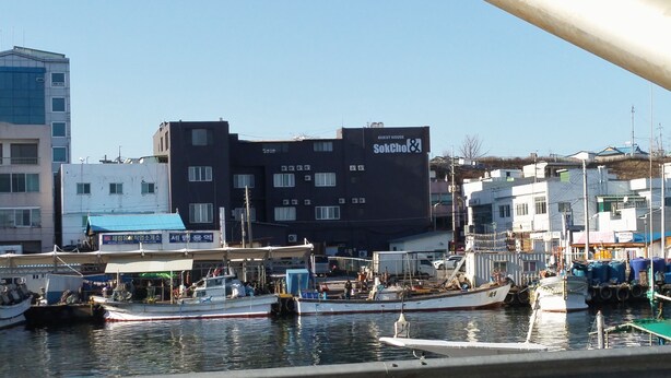 A building with a sign reading "SokChon & Guest House". - Sokcho & Guesthouse (Sokcho)