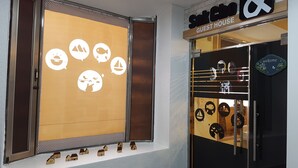 A storefront with a sign reading "SokCino & Guest House". - Sokcho & Guesthouse (Sokcho)