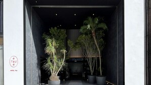 En modern hotellentrén med ett plattlagt golv och krukväxter.
