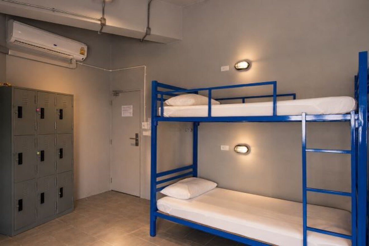 Quarto com beliche, guarda-roupa, porta e ar condicionado.