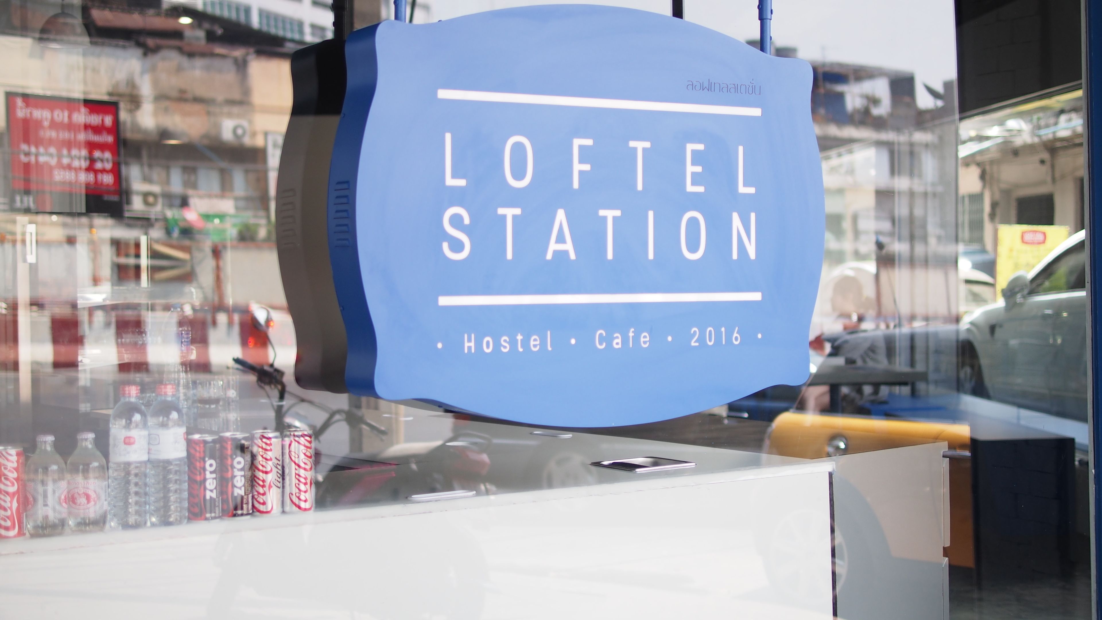 Bordje voor het Loftel Station Hostel Cafe, dat aangeeft dat het een hostel en café is sinds 2016.